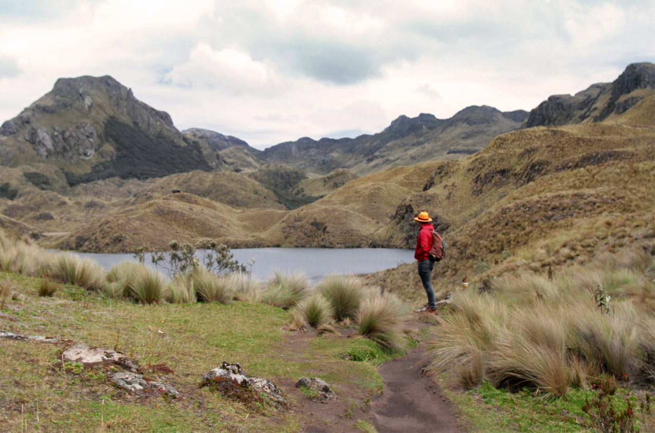 Los Cajas lake with a man in a red jacket looking into the distance