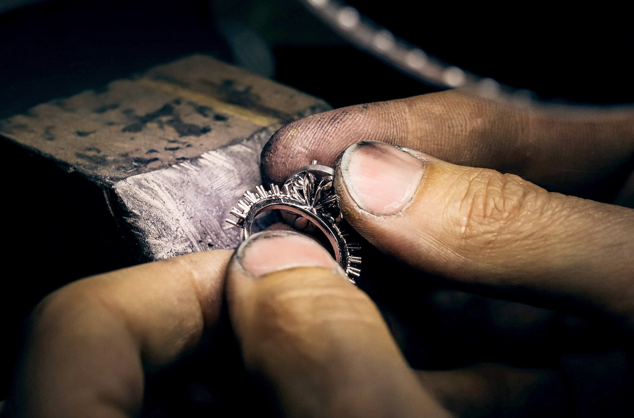 Silver ring being made held in craftsman's fingers