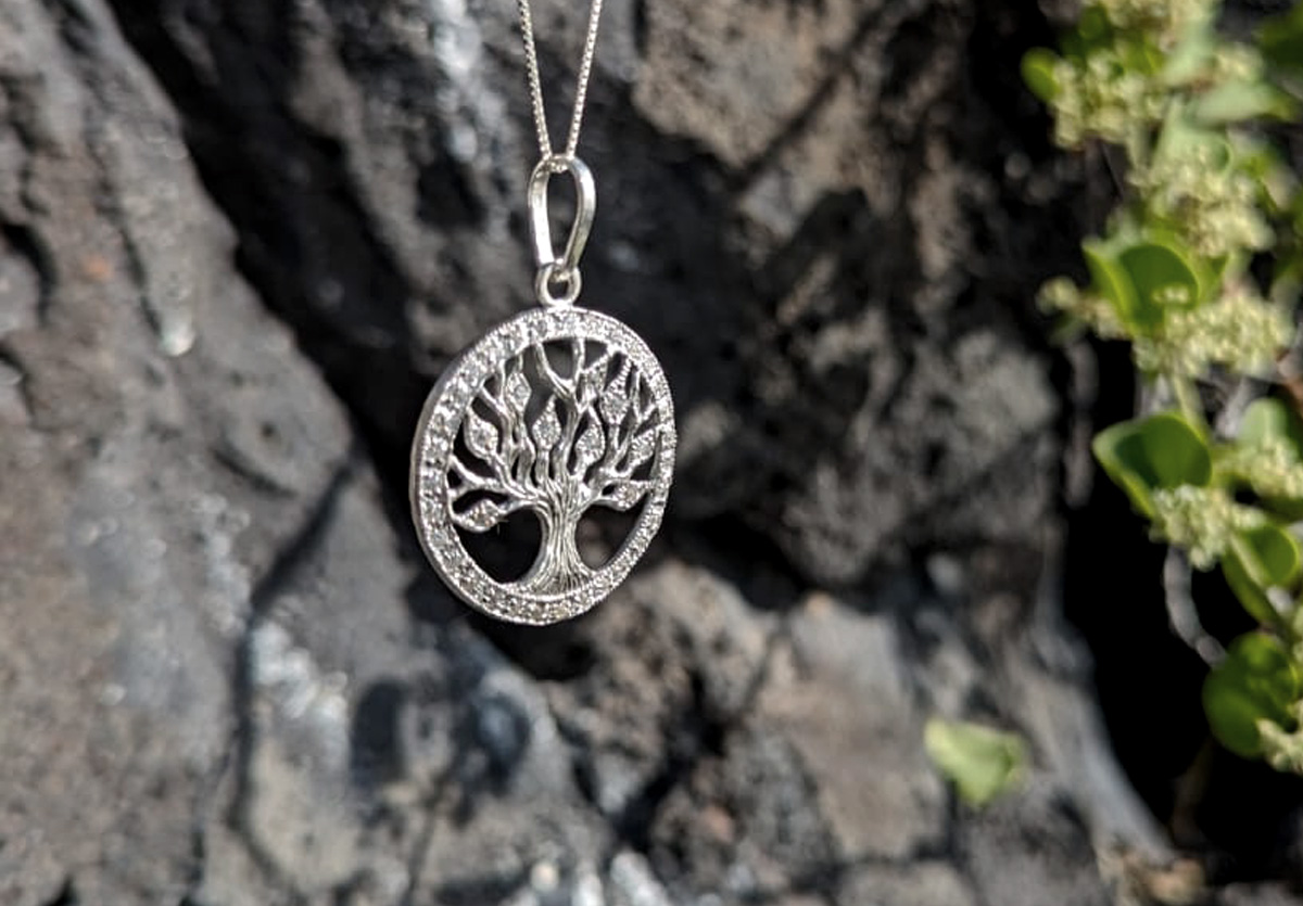 Life tree pendant hanging in front of lava rock