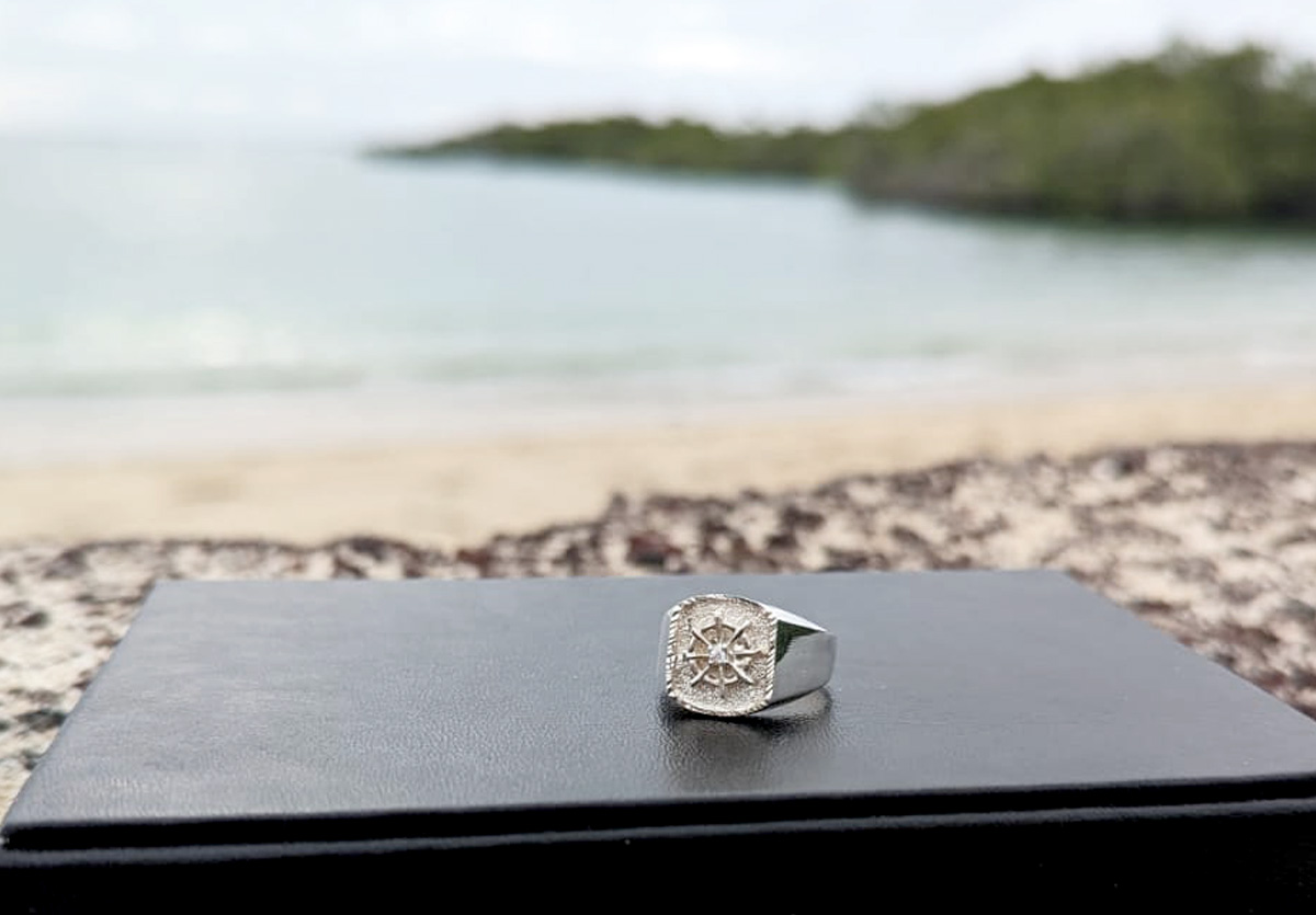 Silver ring with helm on beach