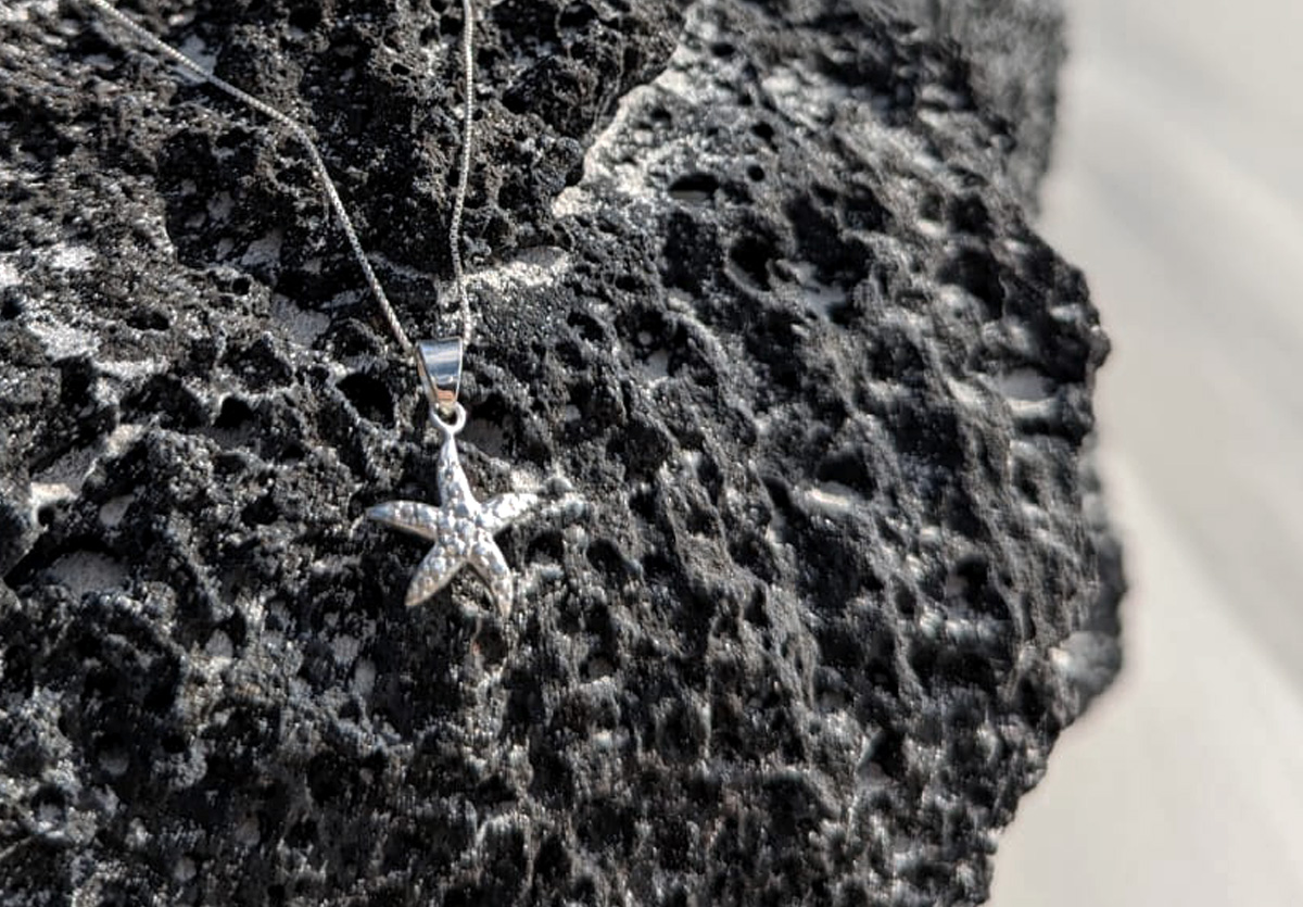 Silver starfish pendant on lava rock